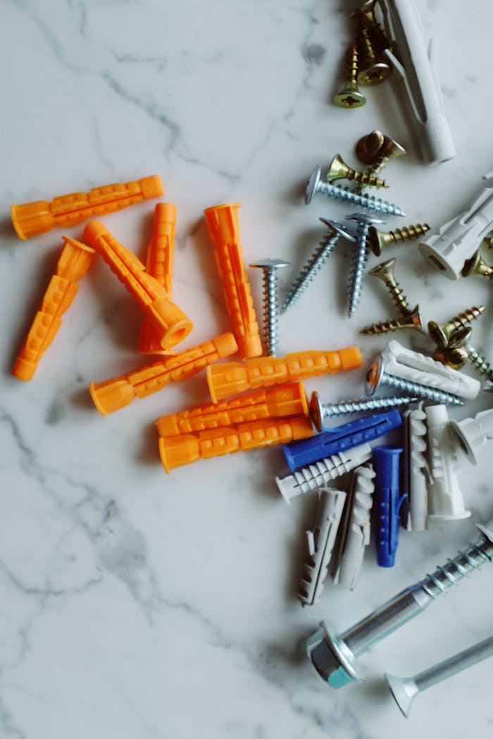 Variety of screws and anchors scattered on a marble background.